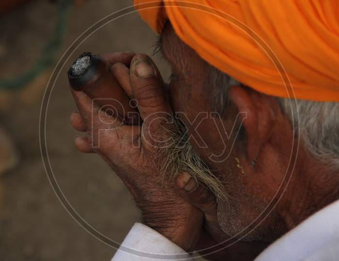 A Camel Traders Smoking Weed or Ganja  at Pushkar Camel Fair, pushkar