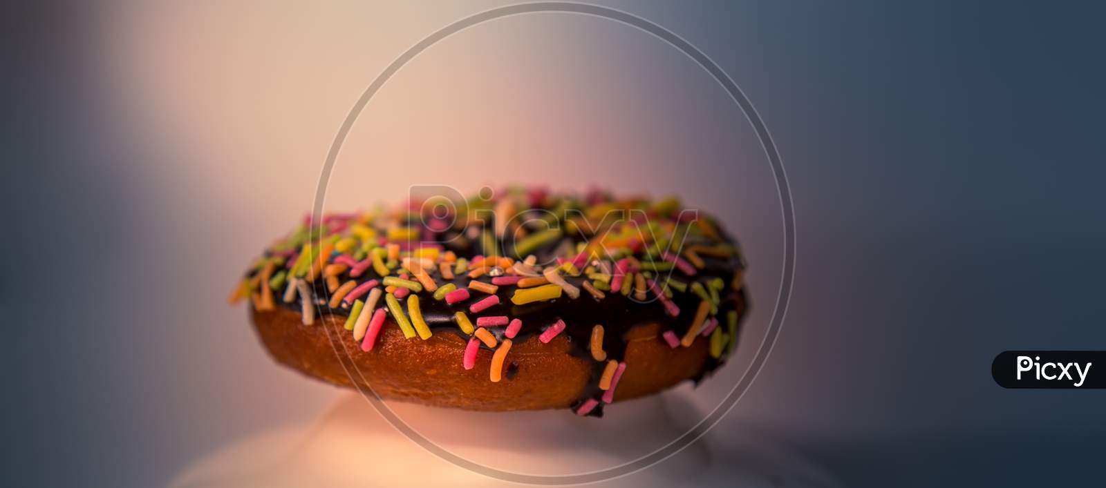 Assorted Donuts With Dark Chocolate Frosted And Sprinkles On It