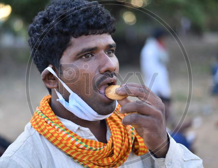 A migrant worker eats a biscuit