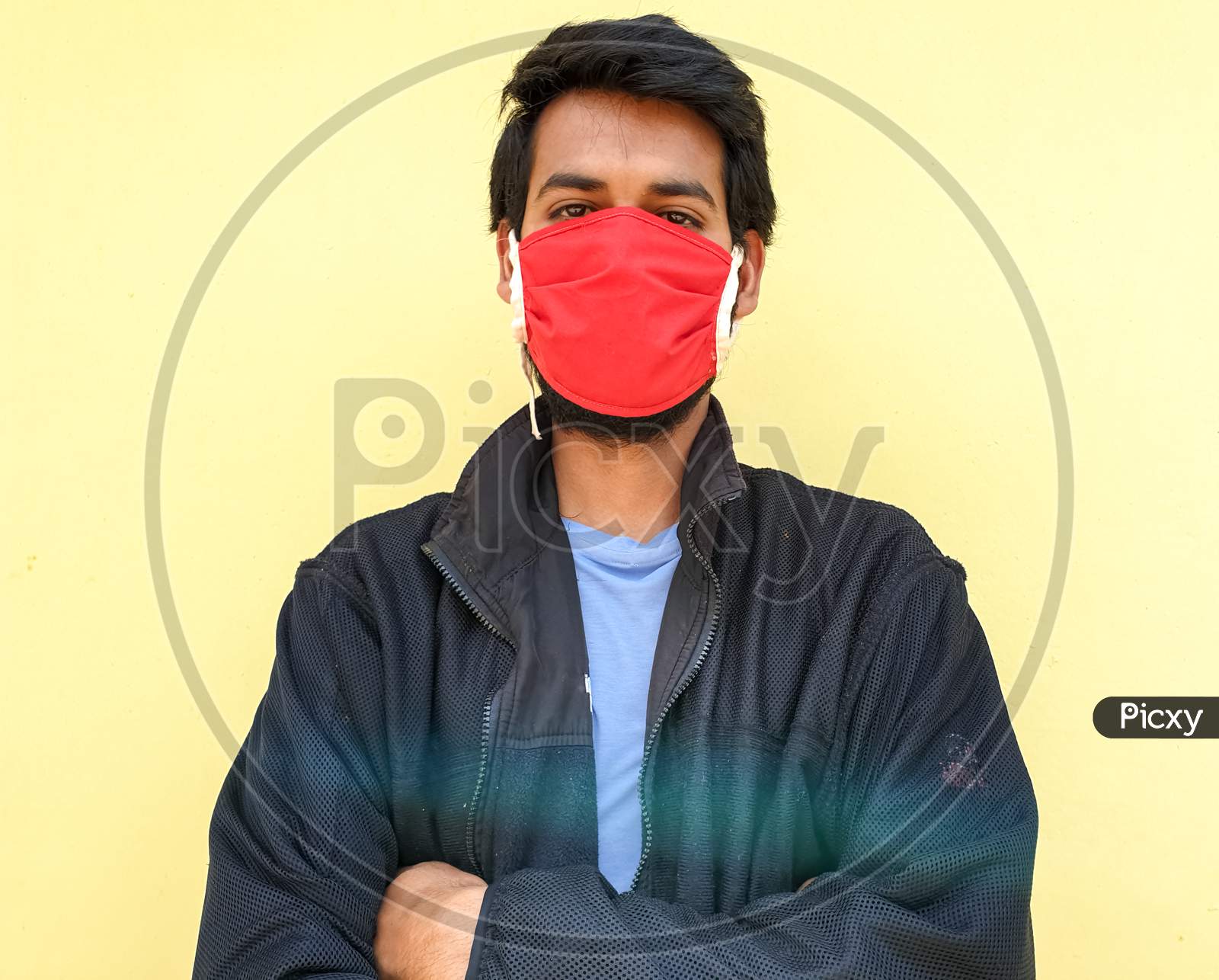 photo of a young indian guy wearing a face mask to protect against the coronavirus during lockdown with selective focus, selective focus on subject, background blur
