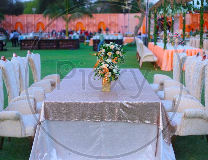 Luxurious Long Dinner Tables And Chairs, Rich Decorated With Flower Pots, Indian Wedding Setup - Image