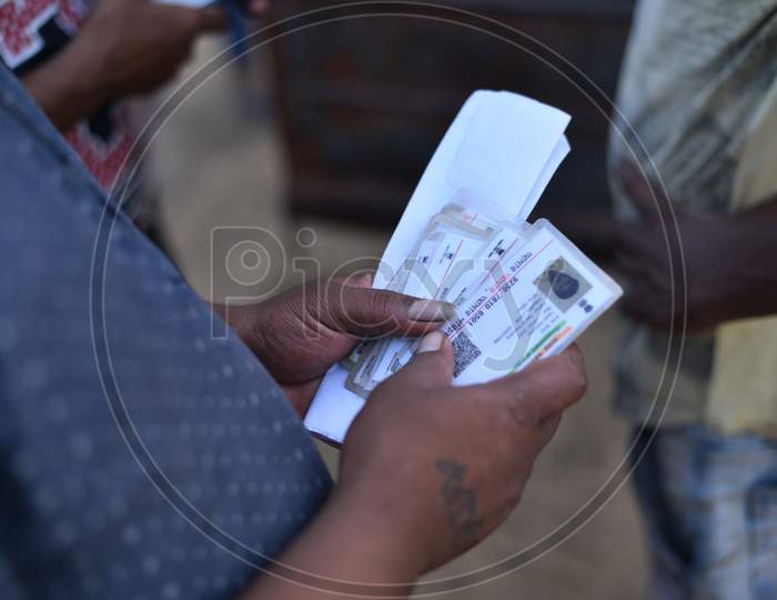 a migrant worker carries Aadhar cards of his colleagues