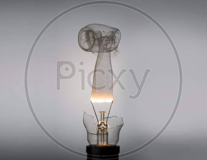 Broken Incandescent light bulb with fire and smoke
