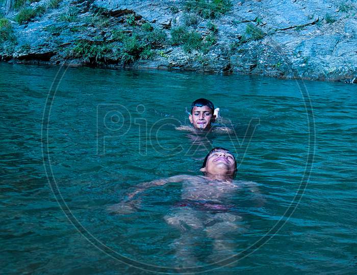 Nerwa Village, Himachal Pradesh, India - July 20Th, 2019: Young Boys Swimming In The Fresh River Water. Summer Vacation Concept