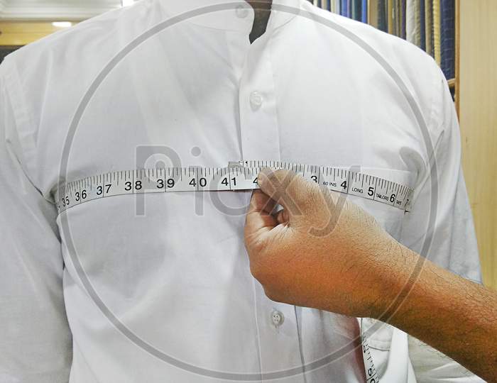 Closeup Of Tailor Taking Measurements Of Man Chest With A Measuring Tape