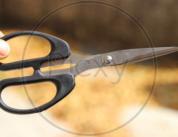 Scissor With Black Handle Used To Cut Paper And Other Objects