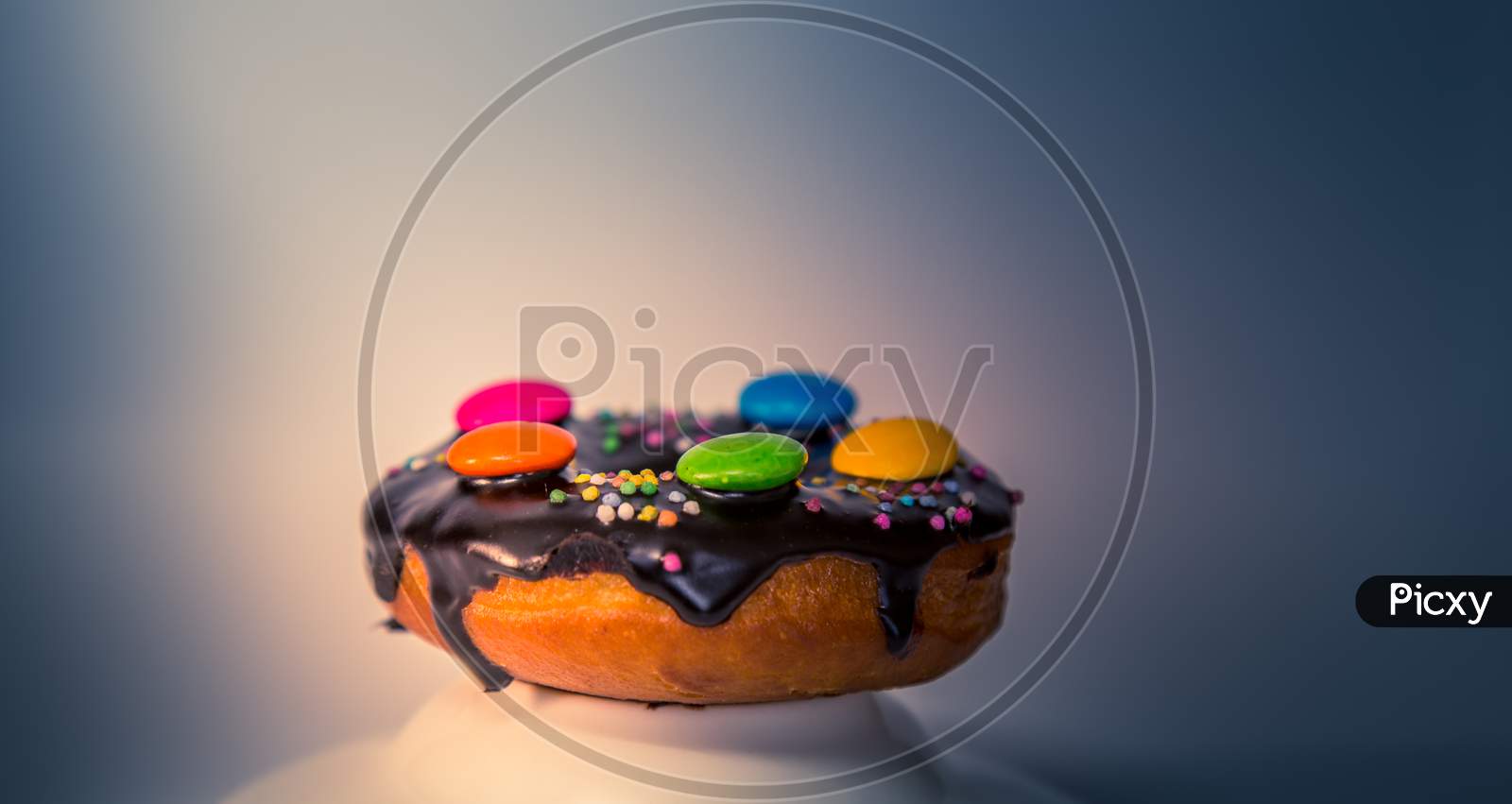 Assorted Donuts With Dark Chocolate Frosted And Gems On It