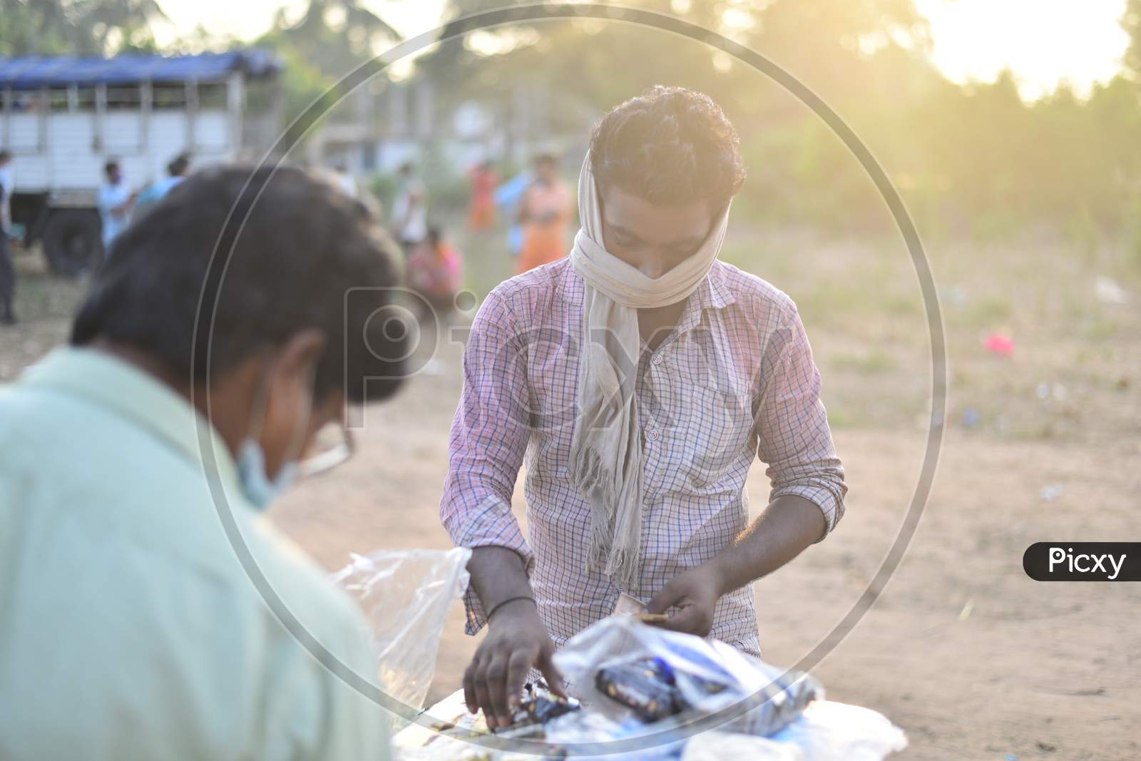 a migrant worker buying biscuits from a vendor