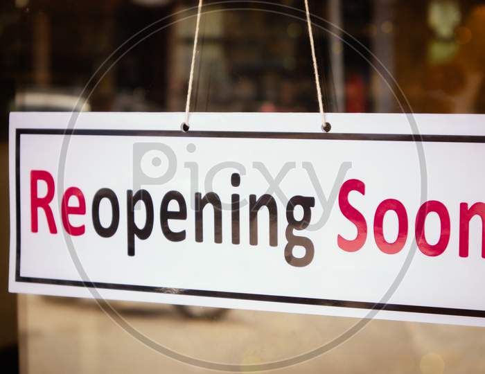 Reopening Soon Signage Board In Front Of Businesses Or Restaurant Door After Covid-19 Or Coronavirus Outbreak - Concept Of Back To Business After Pandemic