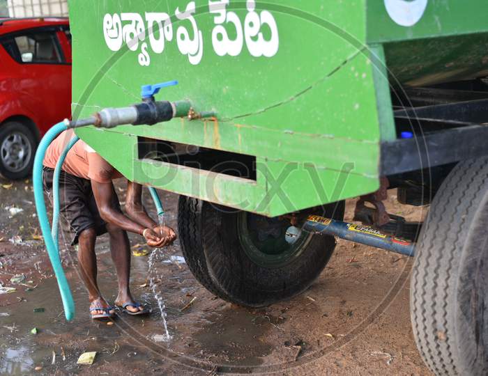 a migrant worker drinks water provided by local authorities of Aswaraopet at the Telangana state border