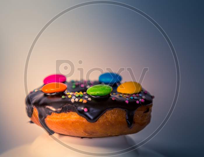 Assorted Donuts With Dark Chocolate Frosted And Gems On It