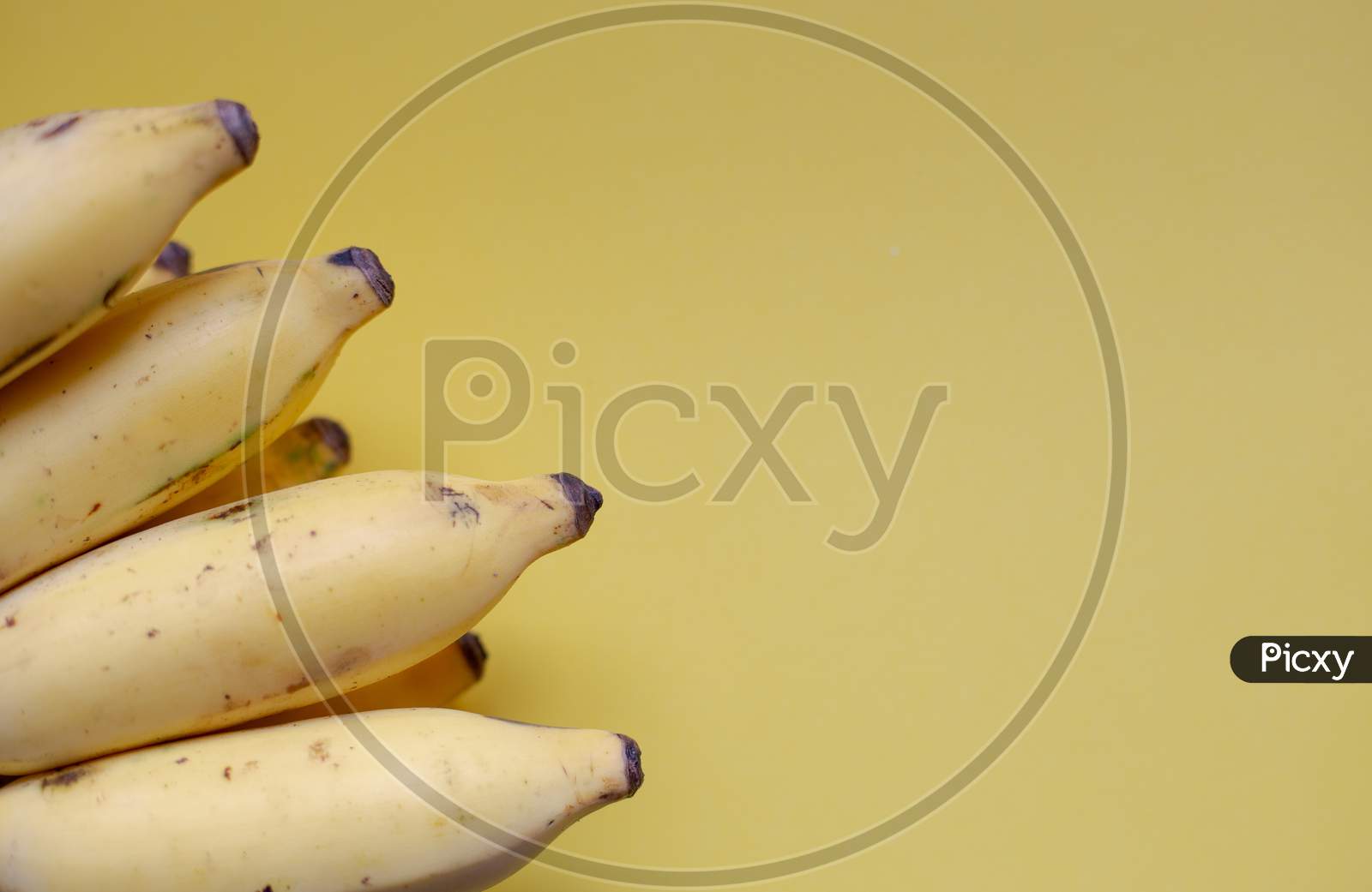 Ripe Bananas On Soft Bright Yellow Background