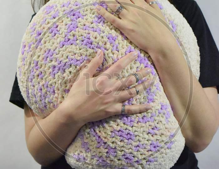 Female Hands Hug A Knitted Pillow