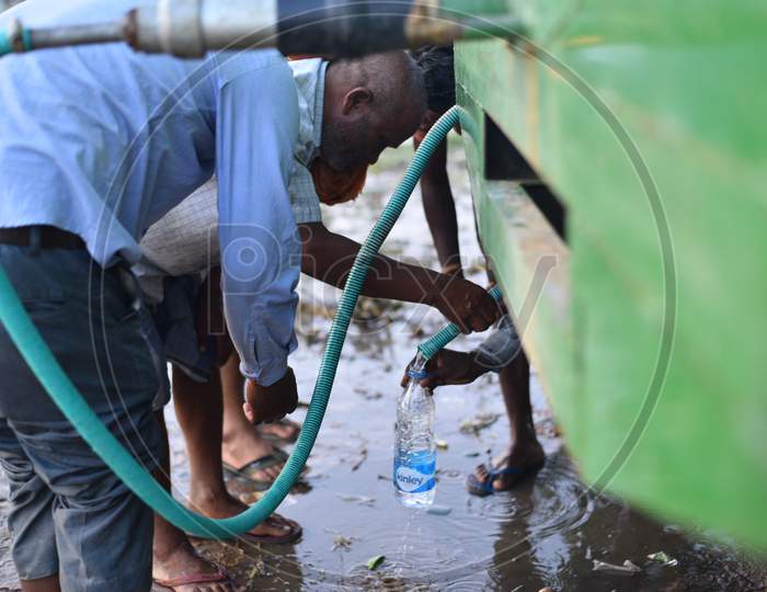 a migrant worker drinks water provided by local authorities of Aswaraopet at the Telangana state border