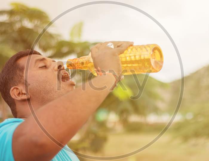 Fat Young Man Drinking Water From Bottle Outdoor - Thirsty Obese Man Drinking Water After Exercise.