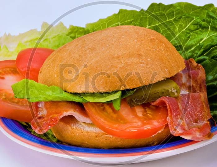 Bread roll with bacon tomato and lettuce.