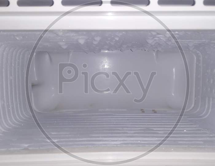Inside the freezer of a refrigerator water vapor frozen on its walls / empty space in freeze