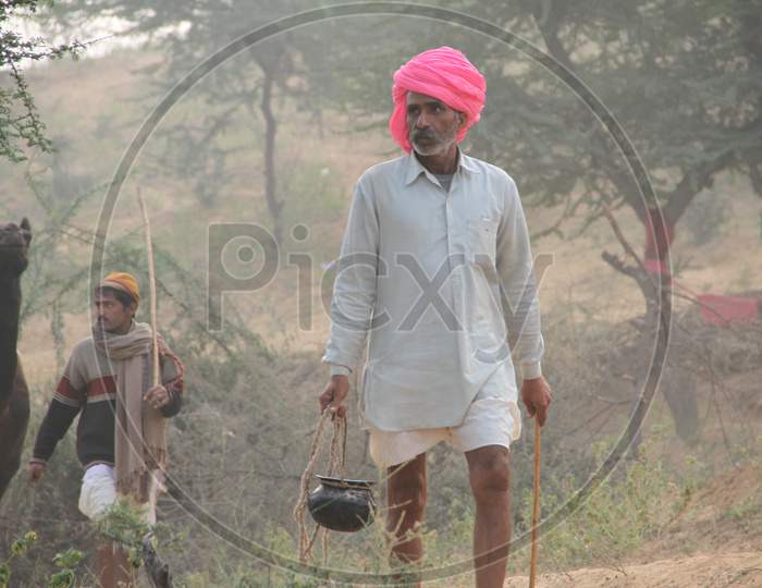 Camel Trader Carrying Food in a Vessel At Pushkar Camel Fair, Pushkar