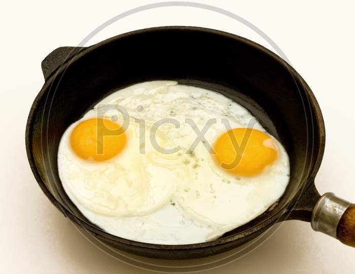 Two fried eggs in a pan.