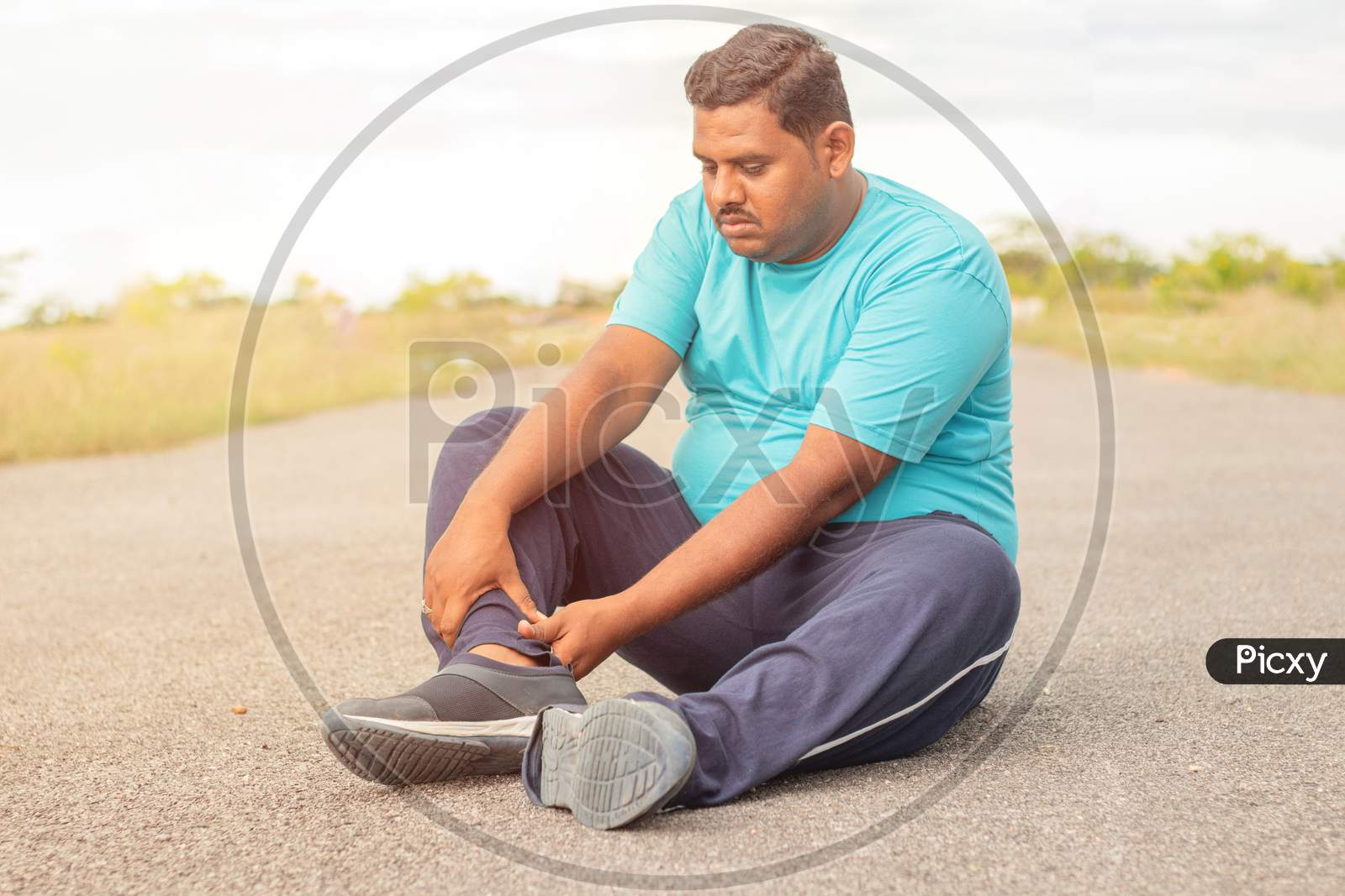 Concept Of Leg Tendon Injury Of Fat Man - Obese Person Holding Leg Suffering Muscle Pain - Overweight Man Fitness Concept At Outdoor Park.