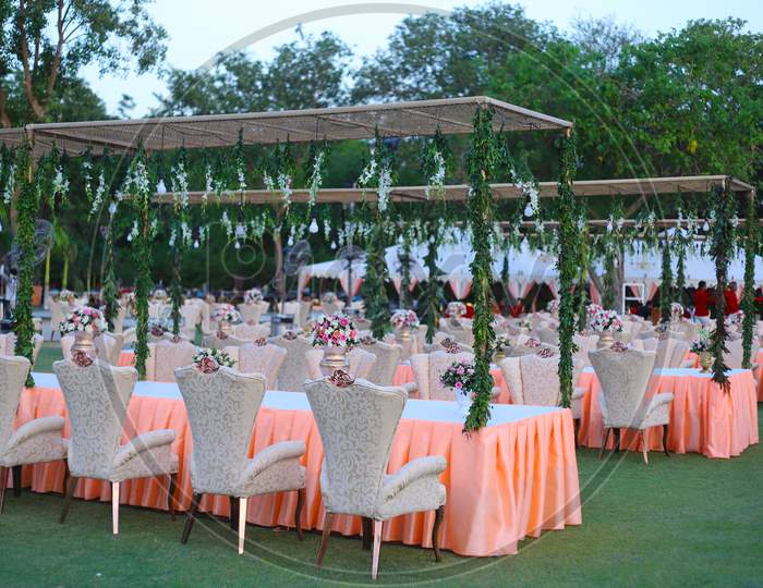 Luxurious Long Dinner Tables And Chairs, Rich Decorated With Flowers , Indian Wedding Arrangement Setup - Image