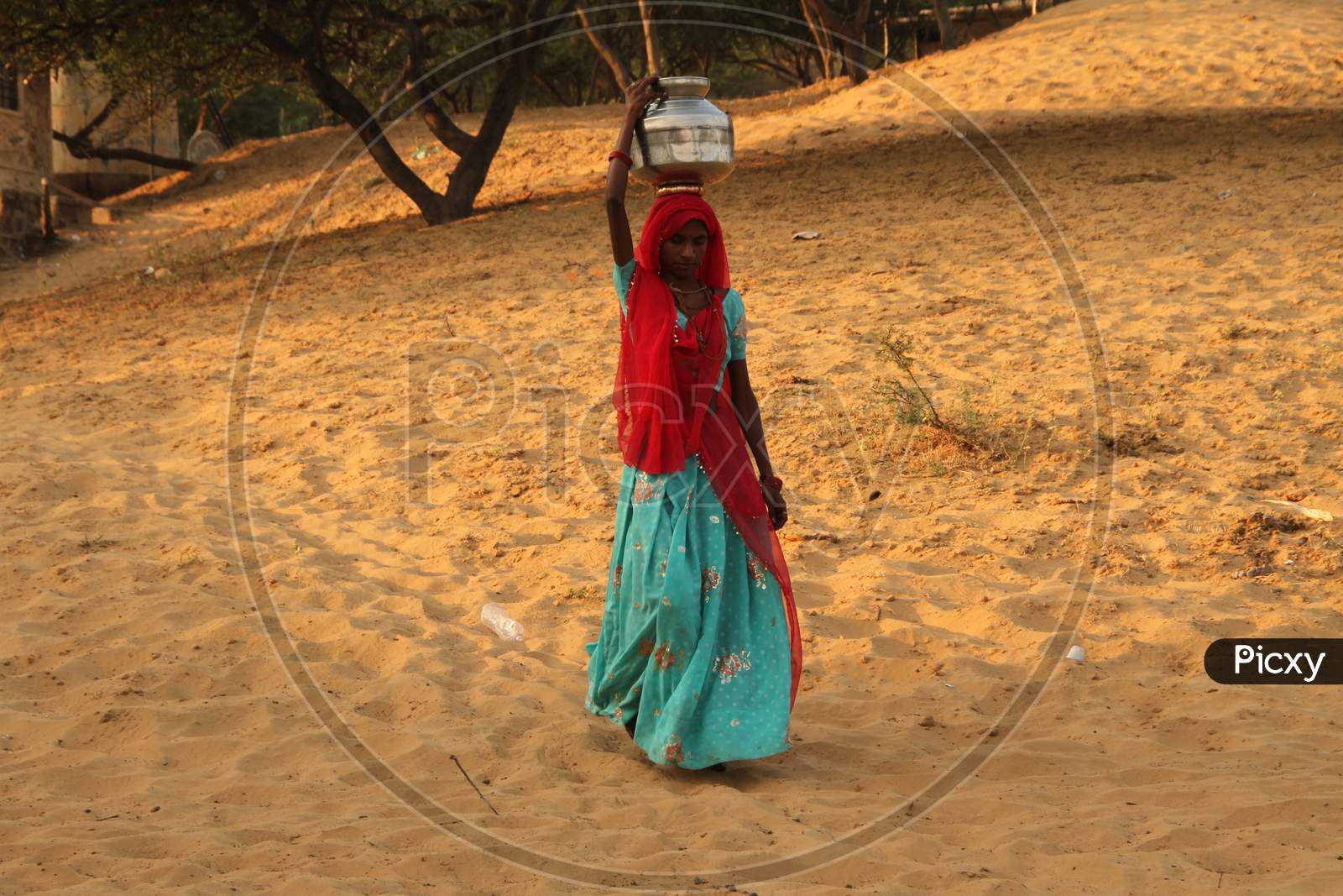 Rajasthani Woman Carrying Water Vessel Over Head At Dessert Villages of Rajasthan