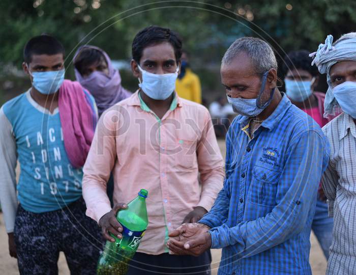 Migrant workers from Bihar eat (Black Gram) Chana as they wait at the Telangana-Andhra Pradesh Border to get permission to cross the border, Aswaraopet, May 16,2020