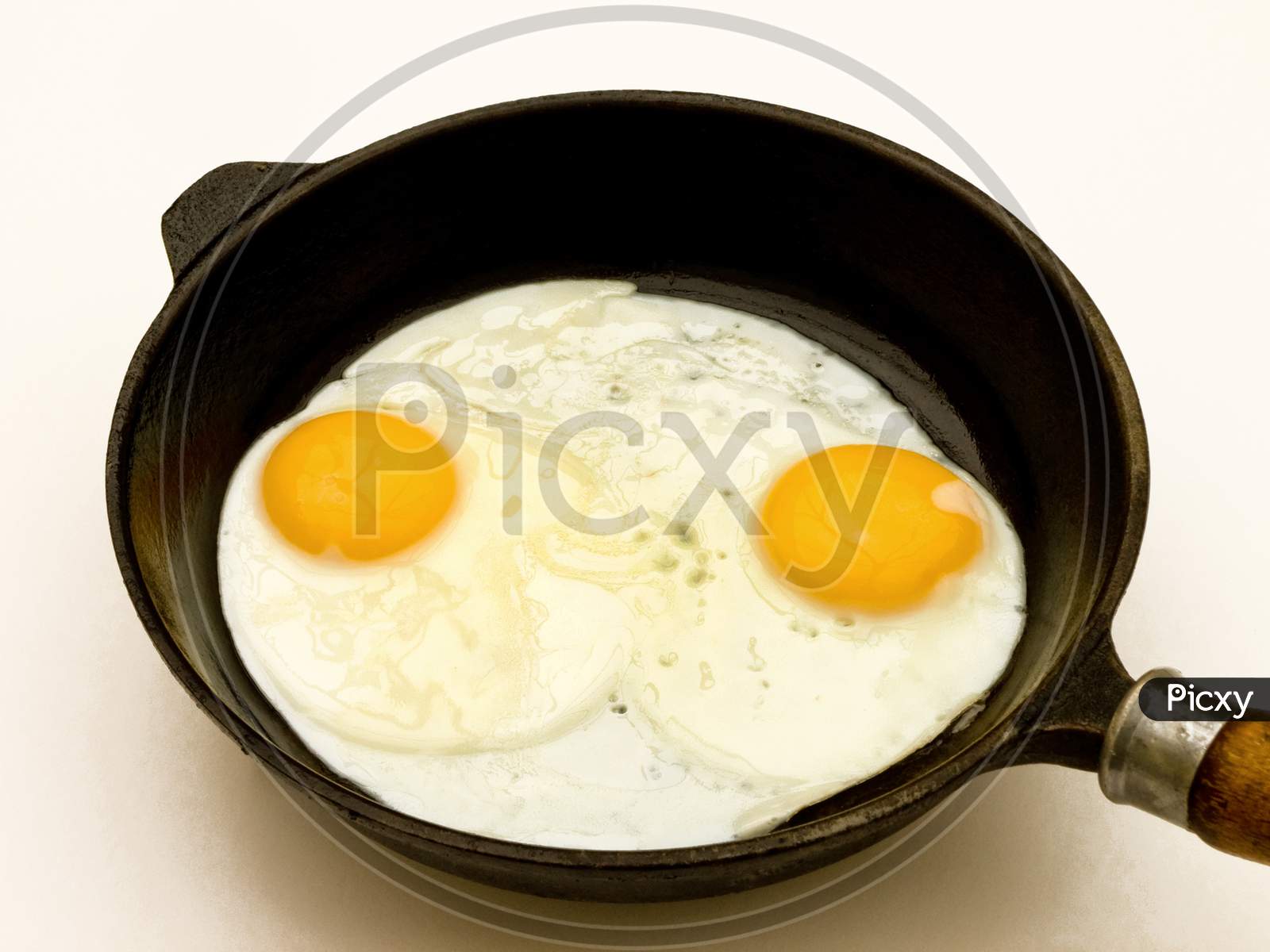 Two fried eggs in a pan.