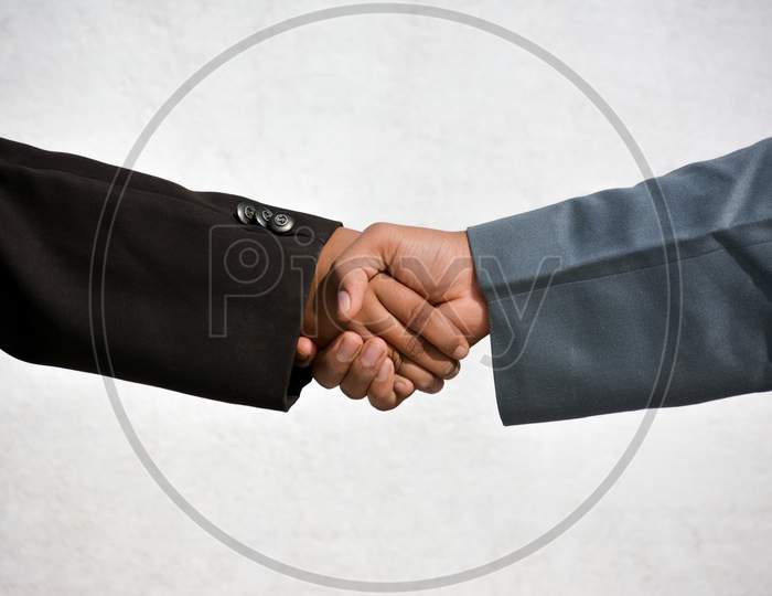 Business and office concept - Two confident business man shaking hands during a meeting