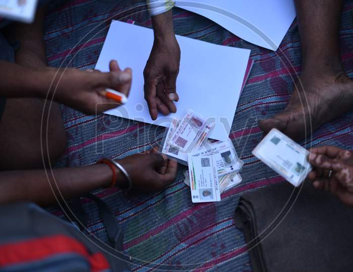 Migrant workers hold their Aadhar Cards to register at Telangana Border to get permission to move till their hometown in Bihar, Aswaraopet, Telangana, May 16,2020