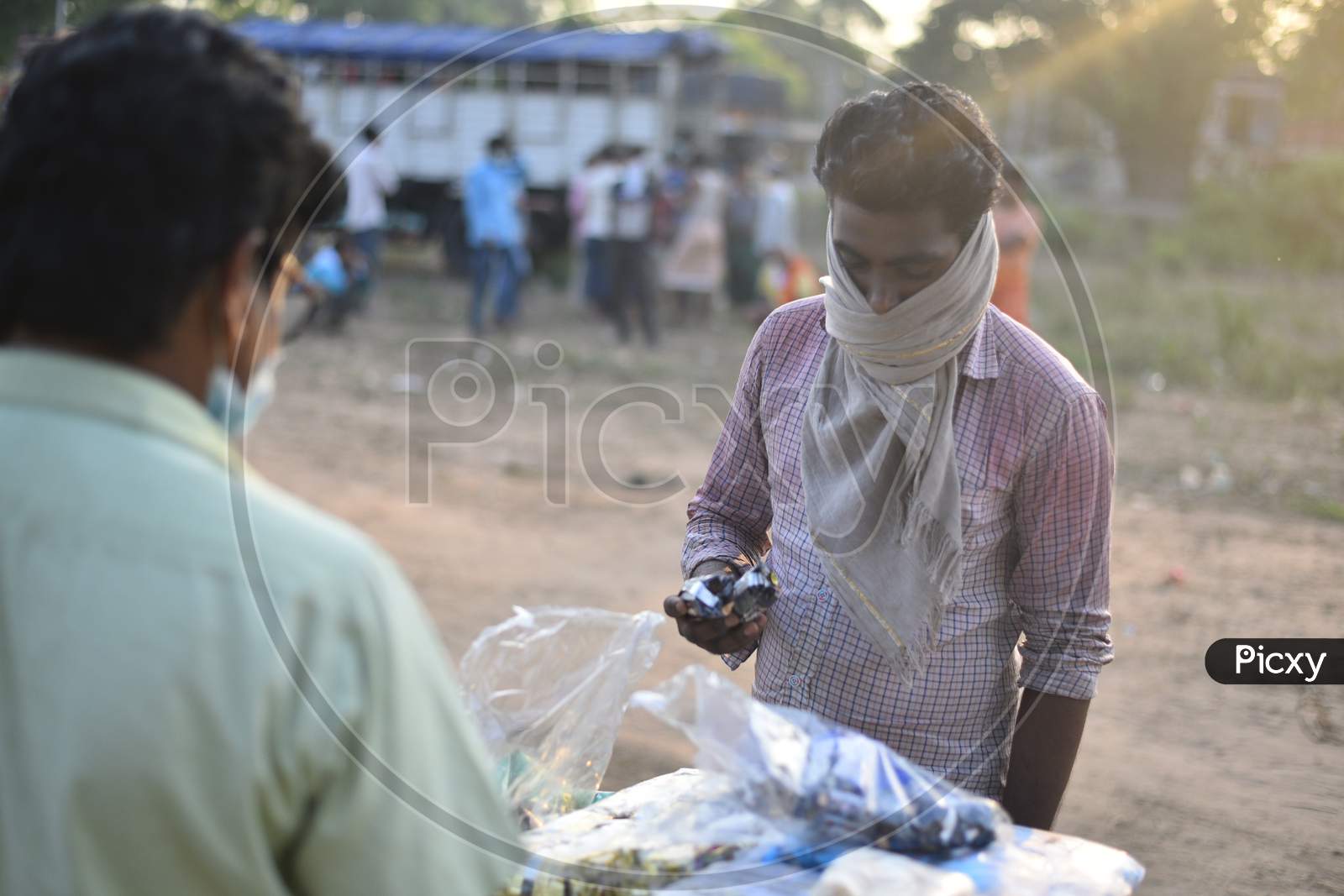 a migrant worker buying biscuits from a vendor