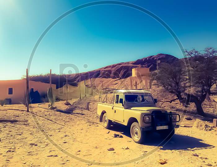 View of an old pickup in desert transporting goods.