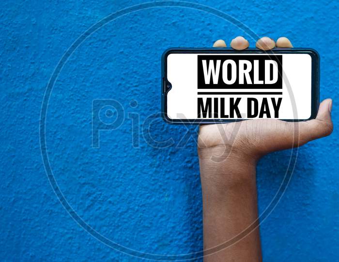 1St June - World Milk Day Wording On The Smart Phone Mobile Screen With Isolated On Blue Background. World Milk Day Wording.
