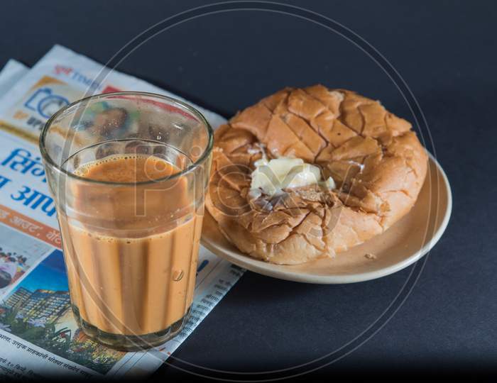 Favorite Indian Breakfst With Tea And Bun Butter Against Black Background