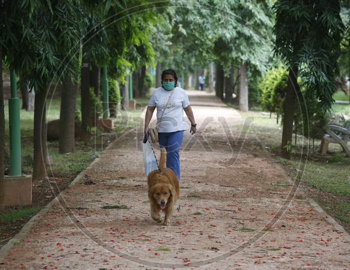 A woman walks her dog in Cubbon Park after the state eased lockdown norms during the nationwide lockdown to prevent the spread of coronavirus (COVID-19) in Bangalore, India.