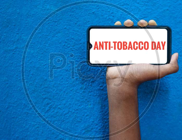 31St May - Anti-Tobacco Day Or World No Tobacco Day Awareness Wording On The Mobile Screen With Isolated On Blue Background.World No Tobacco Day.
