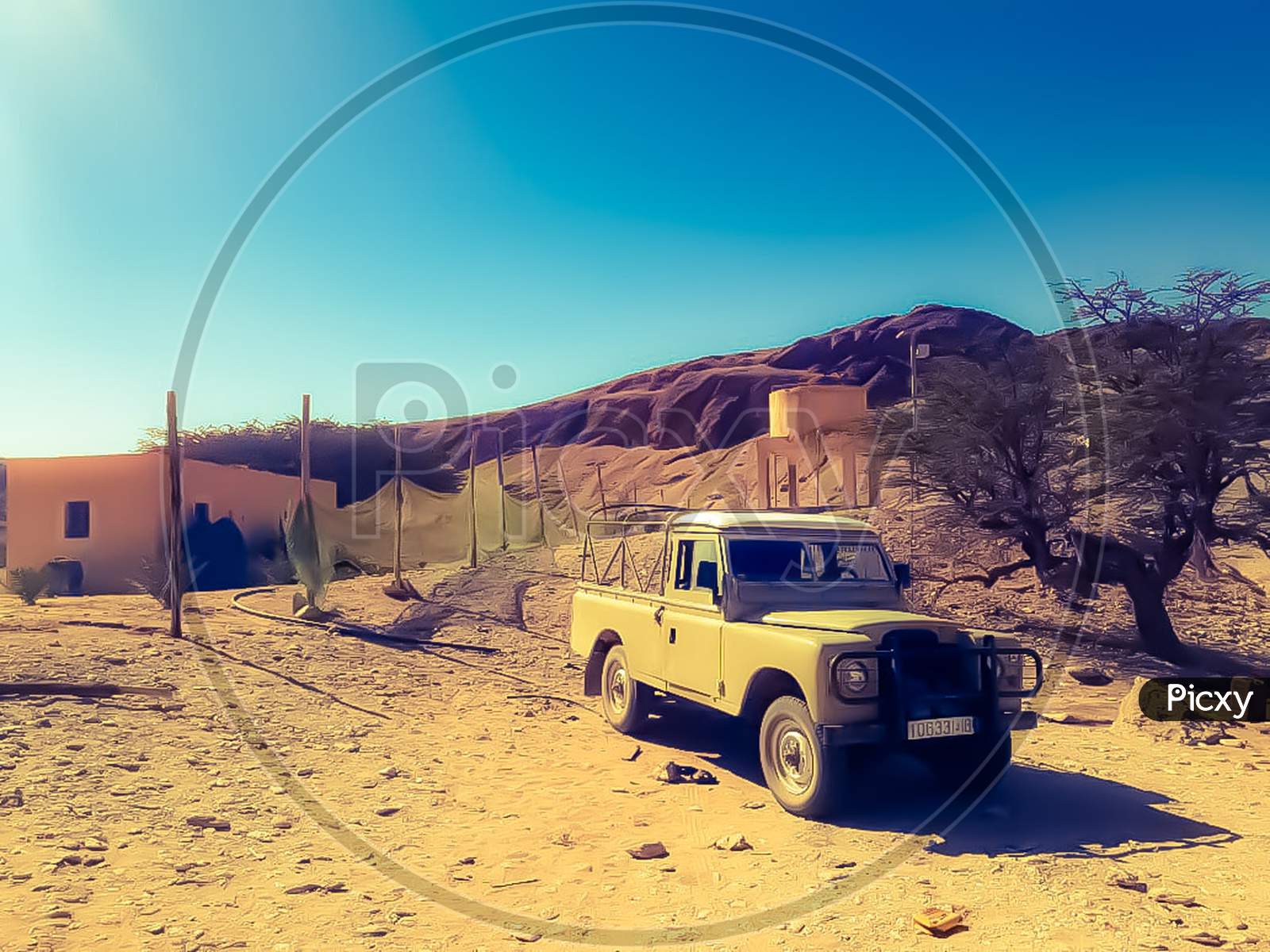 View of an old pickup in desert transporting goods.