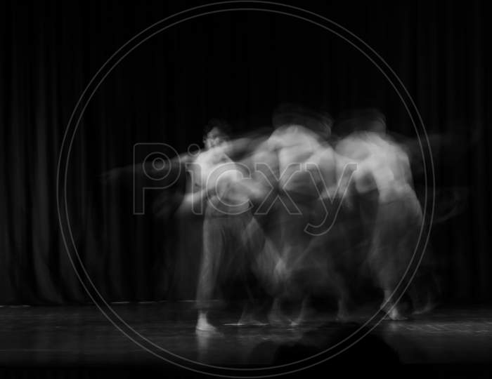 An Artistic Dancer In A Theater Shot With A Slow Shutter Speed In Order To Achieve The Desired Motion Blur.