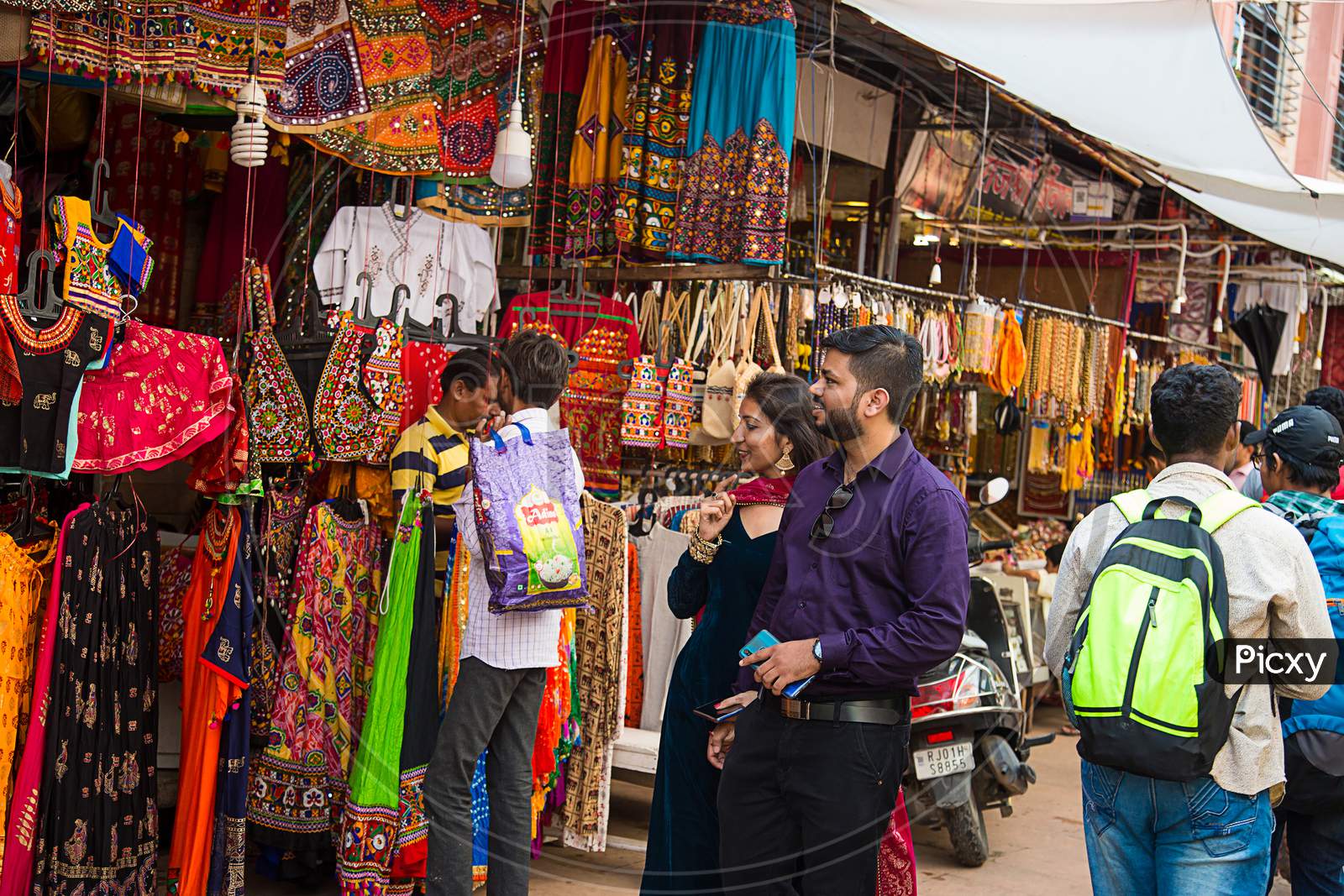 Pushkar, Rajasthan, India - November 14, 2019: Indian Couple Buying Colorful India Style Traditional Ethnic Clothes Shop In The Local Market.