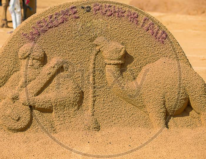 Sand Sculpture Art Of A Man And A Camel At Pushkar Camel Fair.