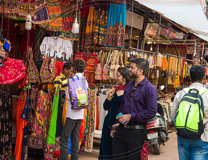 Pushkar, Rajasthan, India - November 14, 2019: Indian Couple Buying Colorful India Style Traditional Ethnic Clothes Shop In The Local Market.
