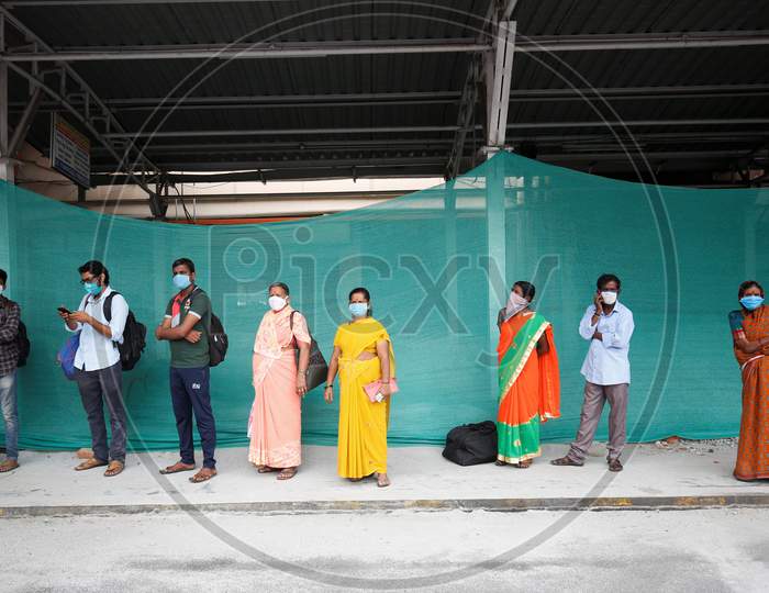 People maintain social distancing as they wait in queue to board a public transport bus after the state eased lockdown norms during the nationwide lockdown to prevent the spread of coronavirus (COVID-19) in Bangalore, India.