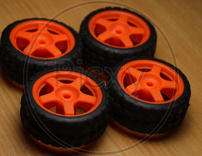 Wheels Of Remote Controlled Car On A Wooden Background