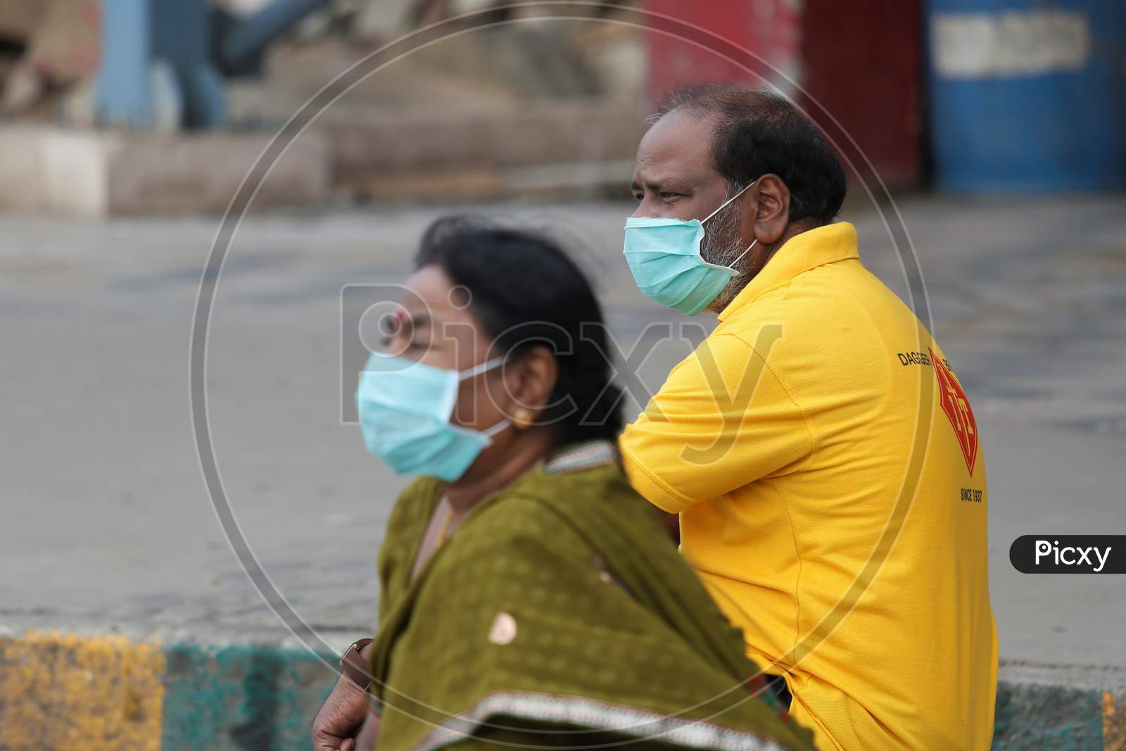 Passengers wear masks and wait for public transport buses in a bus station after the state eased lockdown norms during the nationwide lockdown to prevent the spread of coronavirus (COVID-19) in Bangalore, India.