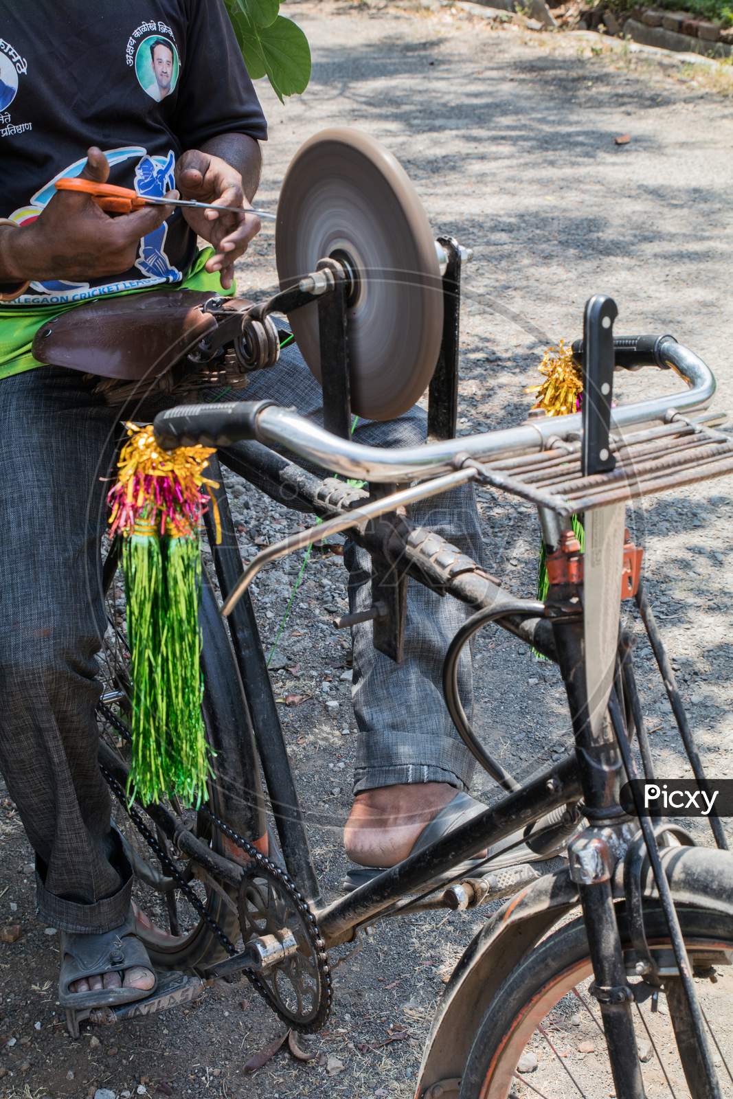 View Of A Guy Sharpening Tools On His Bicycle