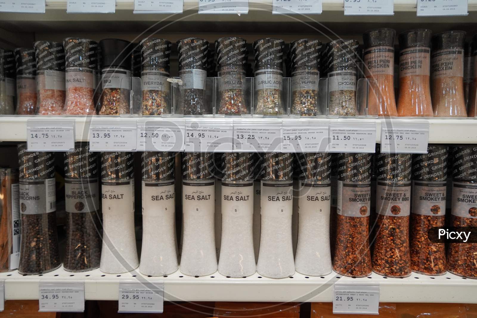 Dubai uae December 2019 Sea salt, pepper, spices, herbs, coriander etc put in shelves for sale. Shelves with herbs, spices and seasonings in a supermarket. Glass jars of spices in a shop.