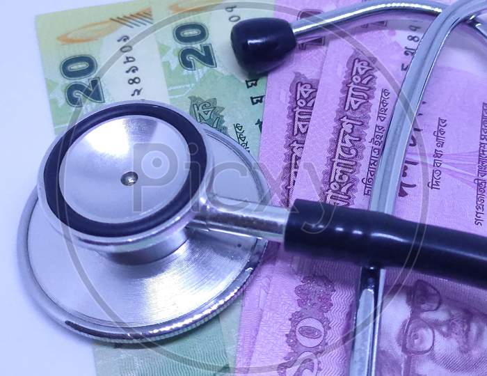 Stethoscope on Bangladeshi bank notes in concept of medical expense.