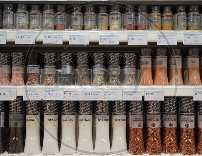 Dubai uae December 2019 Sea salt, pepper, spices, herbs, coriander etc put in shelves for sale. Shelves with herbs, spices and seasonings in a supermarket. Glass jars of spices in a shop.