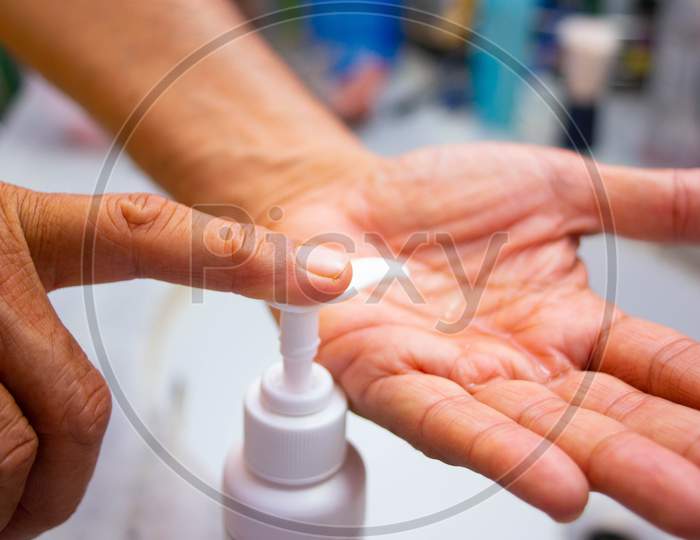 A Person Applying Liquid Soap Or Sanitizer On His Hands