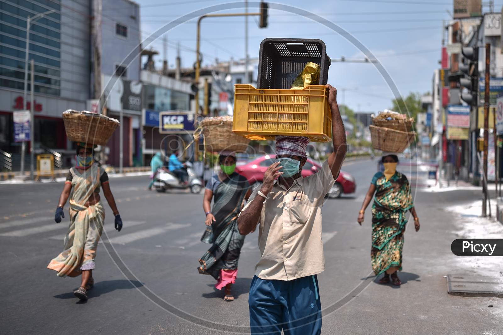 Fruit And Vegetable Sellers Wearing Face Masks Cross A Road During The Nationwide Lockdown Imposed In The Wake Of Coronavirus, In Vijayawada.